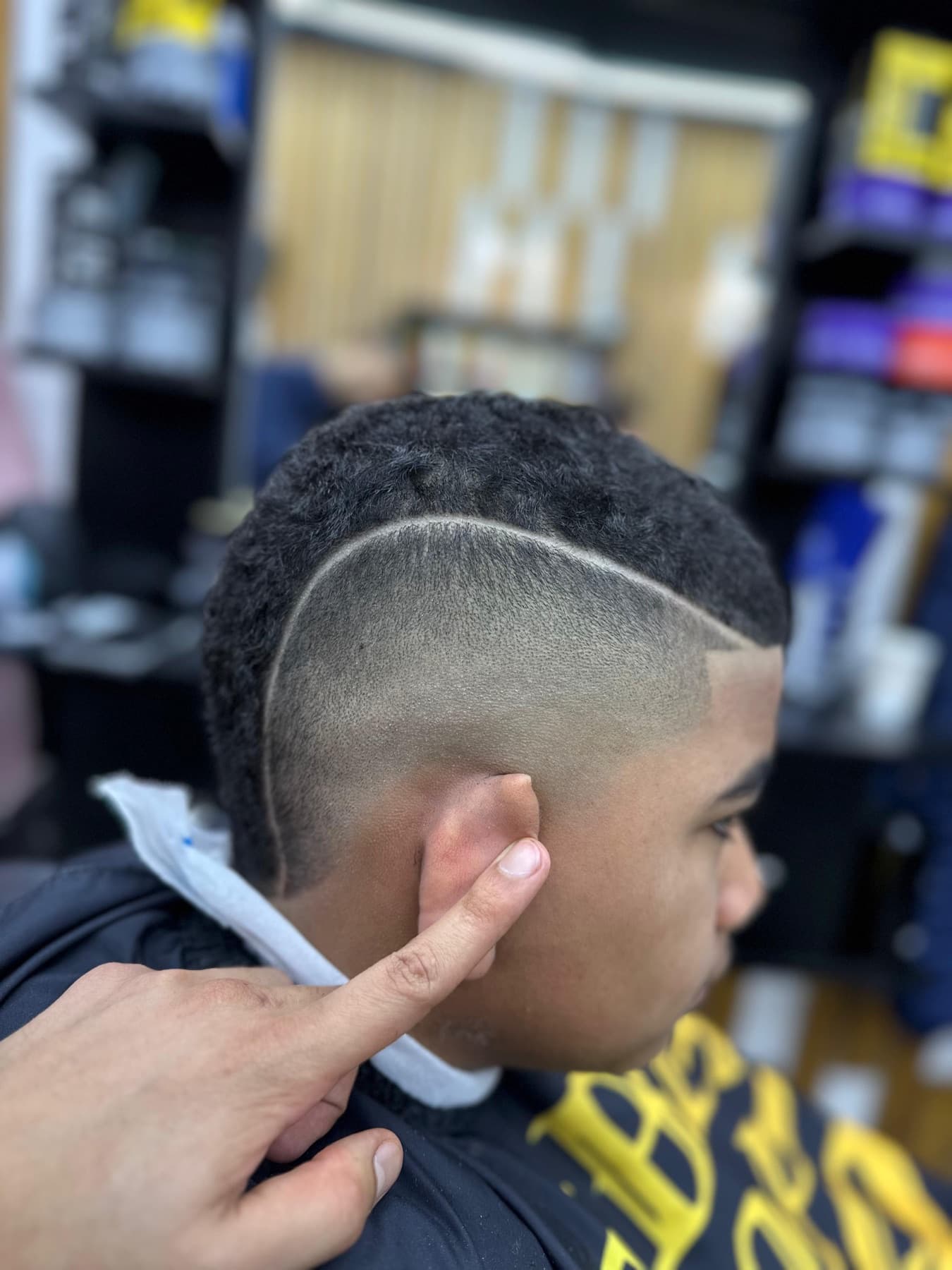 Pelo rizado con degradado y línea a navaja